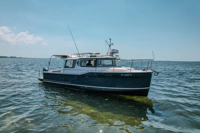 Slide: The Image of 2024 FML R27 LE boat on calm water under clear blue sky. - 2