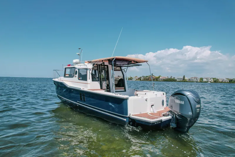 Slide: The Image of 2024 FML R27 LE boat with Yamaha engine on calm water under clear sky. - 20
