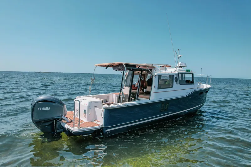 Slide: The Image of 2024 FML R27 LE boat on calm water with Yamaha outboard motor. - 25