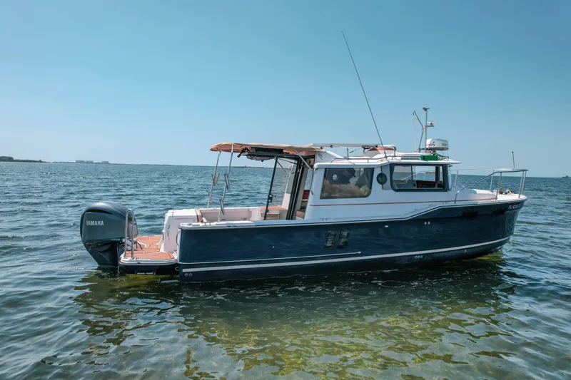 Slide: The Image of 2024 FML R27 LE boat on calm water with Yamaha outboard motor. - 26