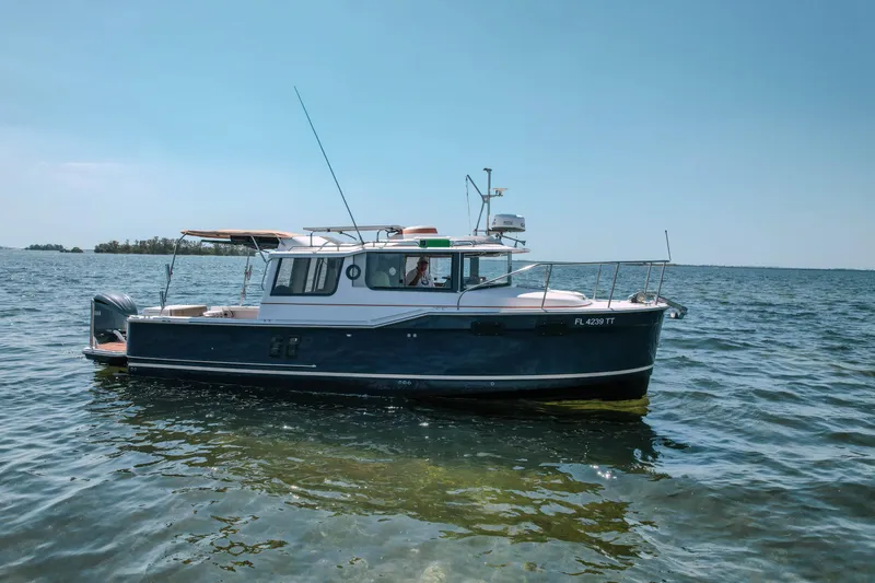 Slide: The Image of 2024 FML R27 LE boat on calm water under clear blue sky. - 28