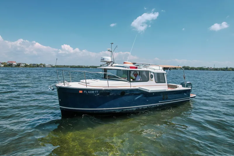 Slide: The Image of 2024 FML R27 LE boat on calm water under clear blue sky. - 29