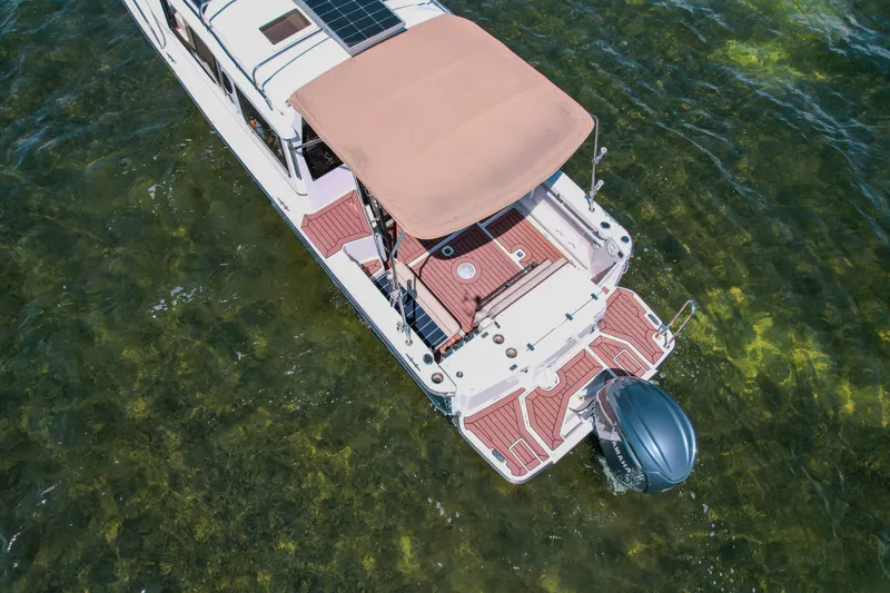 Slide: The Image of Aerial view of 2024 FML R27 LE boat with canopy on clear water. - 33