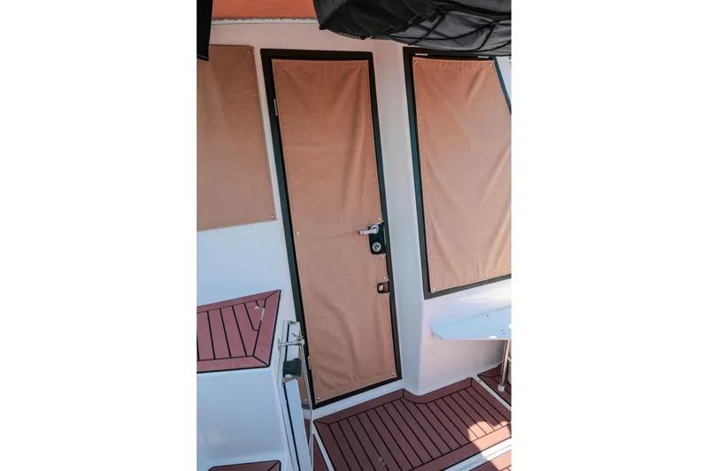 Slide: The Image of 2024 FML R27 LE boat interior with tan door covers and wood-patterned flooring. - 34