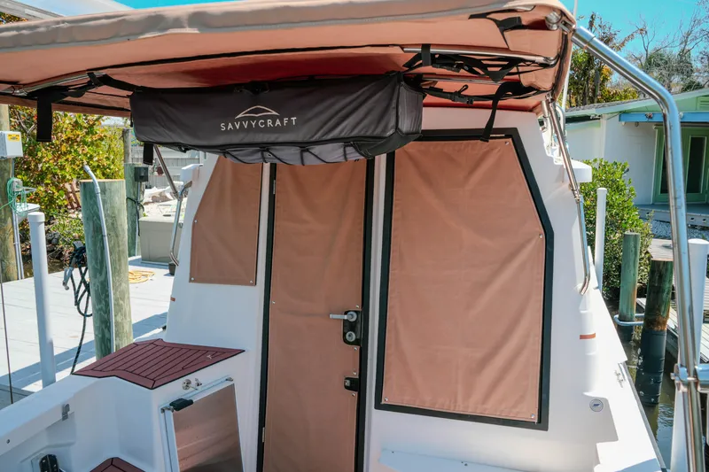 Slide: The Image of 2024 FML R27 LE boat with Savvycraft canopy and tan covers at dock. - 36