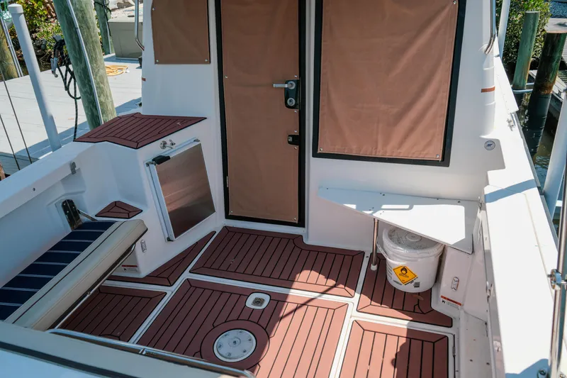 Slide: The Image of 2024 FML R27 LE boat interior with wood flooring and seating area. - 37