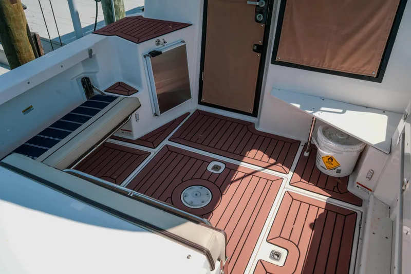 Slide: The Image of 2024 FML R27 LE boat interior with wood-patterned flooring and seating area. - 38