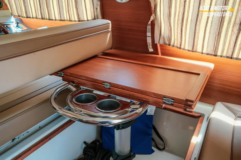 Slide: The Image of 2024 Ranger Tugs R-27 interior with wooden table and cup holders. - 46