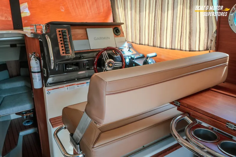 Slide: The Image of 2024 Ranger Tugs R-27 interior with helm, Garmin display, and seating. - 47