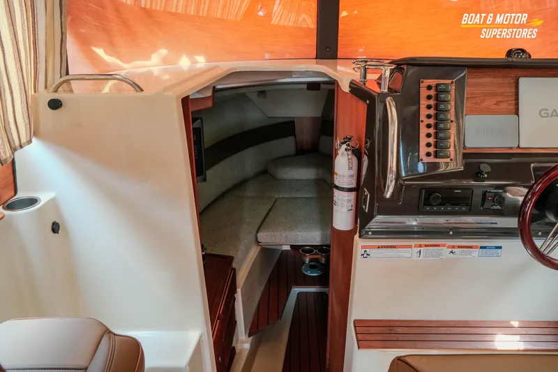 Slide: The Image of 2024 Ranger Tugs R-27 cabin interior with helm, seating, and control panel. - 53