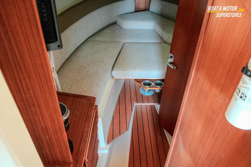Slide: The Image of 2024 Ranger Tugs R-27 cabin interior with wood finish and cushioned seating. - 55