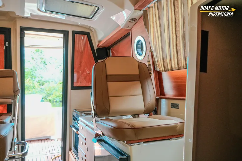 Slide: The Image of 2024 Ranger Tugs R-27 interior with comfortable seating and elegant wood finishes. - 60