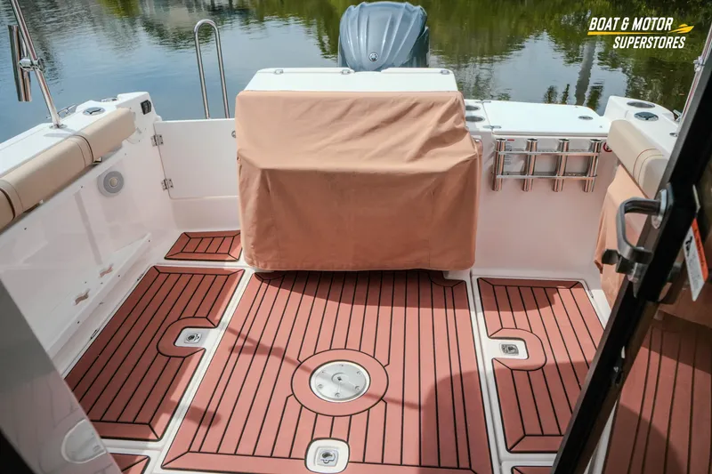 Slide: The Image of 2024 Ranger Tugs R-27 boat deck with teak flooring and covered seating area. - 63