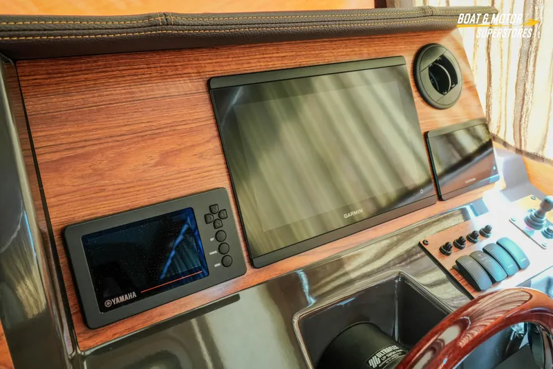 Slide: The Image of 2024 Ranger Tugs R-27 dashboard with Garmin and Yamaha displays, wood finish. - 68