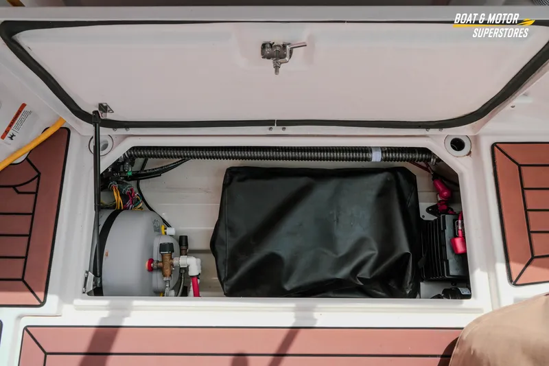 Slide: The Image of 2024 Ranger Tugs R-27 storage compartment with mechanical components and wiring. - 70