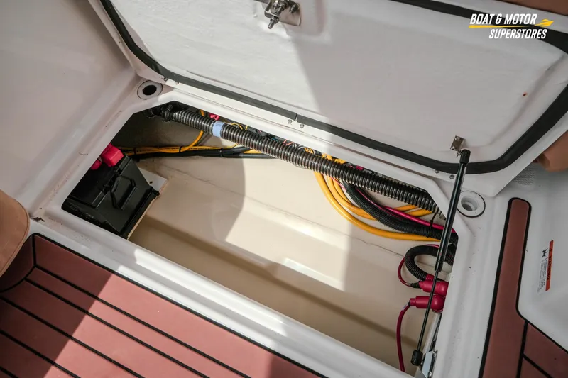 Slide: The Image of 2024 Ranger Tugs R-27 storage compartment with wiring and battery setup. - 72