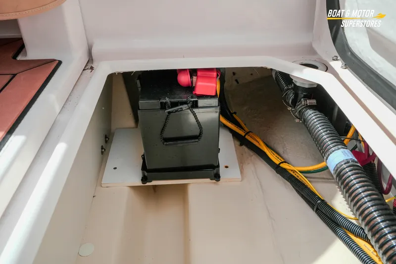Slide: The Image of 2024 Ranger Tugs R-27 battery compartment with wiring and storage space. - 73