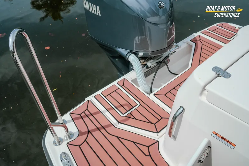 Slide: The Image of 2024 Ranger Tugs R-27 boat stern with Yamaha outboard motor and teak-style decking. - 79
