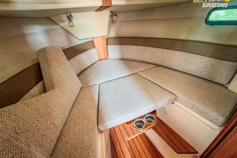 Slide: The Image of 2024 Ranger Tugs R-27 cabin interior with cushioned seating and wooden flooring. - 85