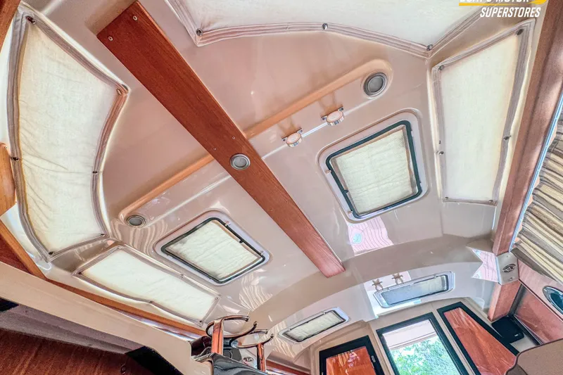 Slide: The Image of Interior ceiling of 2024 Ranger Tugs R-27 boat with wooden accents and windows. - 86