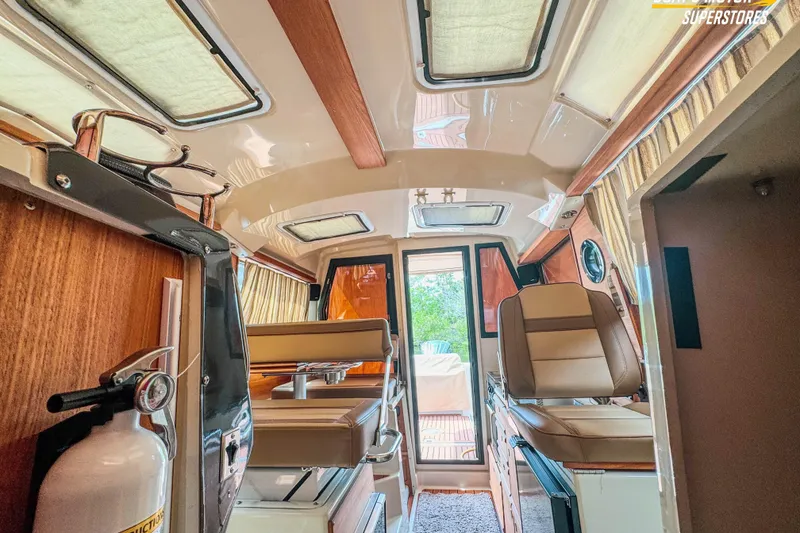 Slide: The Image of Interior of 2024 Ranger Tugs R-27 boat, featuring seating and wood accents. - 87