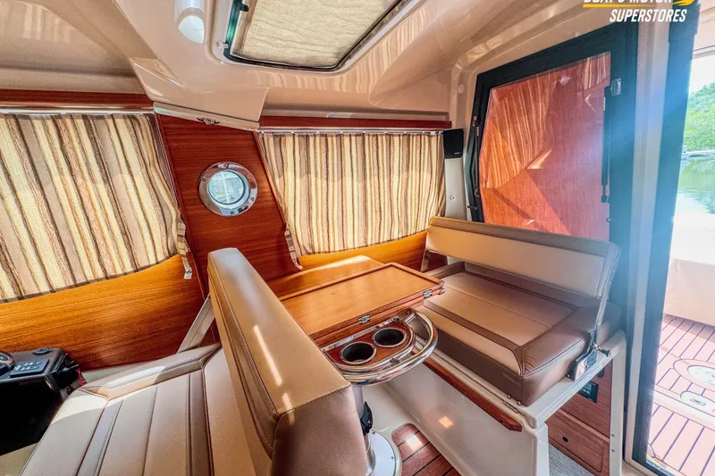 Slide: The Image of 2024 Ranger Tugs R-27 interior with wood accents and striped curtains. - 91