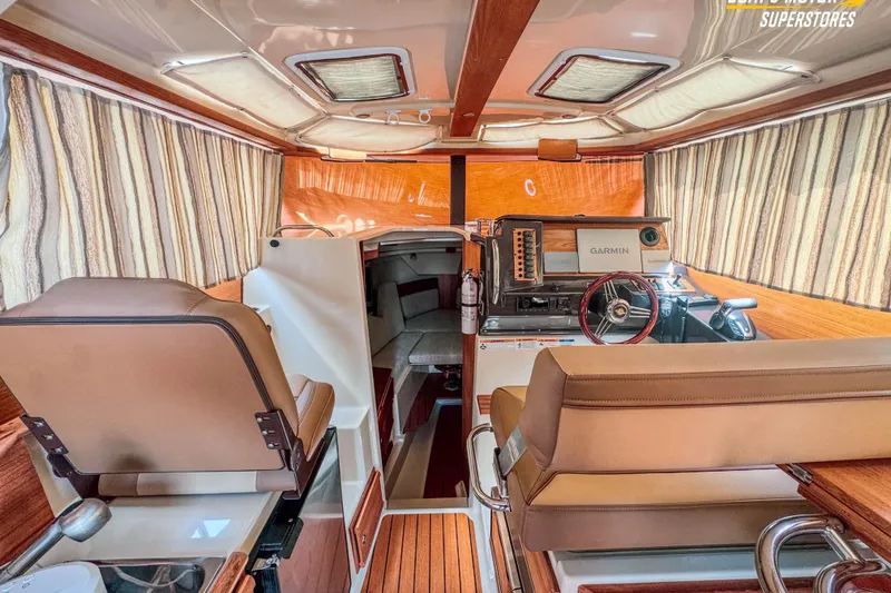 Slide: The Image of Interior of 2024 Ranger Tugs R-27 boat with helm, seating, and navigation equipment. - 92