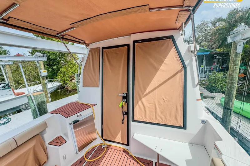 Slide: The Image of 2024 Ranger Tugs R-27 boat interior with tan canvas covers and wood accents. - 94