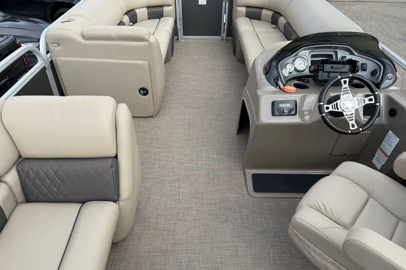 Slide: The Image of 2022 Sun Tracker Party Barge 20 DLX interior with beige seating and modern helm. - 10