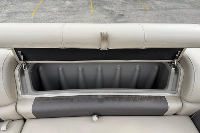 Slide: The Image of 2022 Sun Tracker Party Barge 20 DLX storage compartment with open seat cushion. - 18