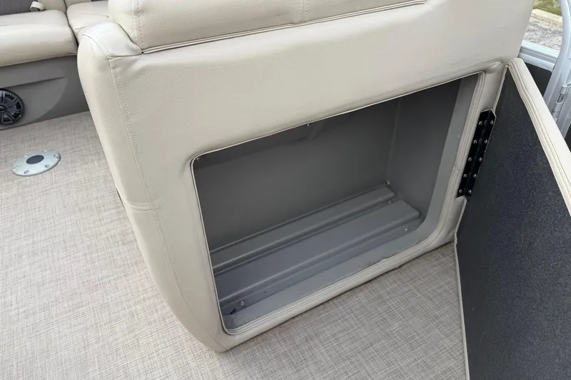 Slide: The Image of 2022 Sun Tracker Party Barge 20 DLX storage compartment with beige seating and carpeted floor. - 4