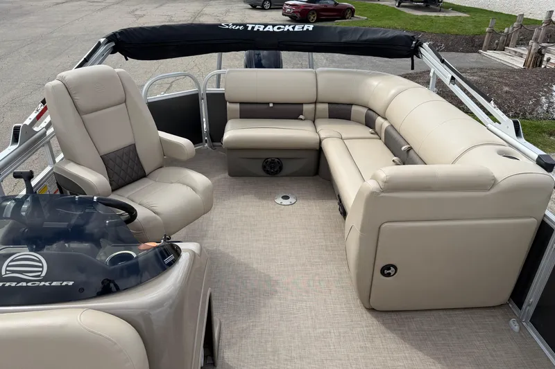 Slide: The Image of 2022 Sun Tracker Party Barge 20 DLX interior with beige seating and steering console. - 9