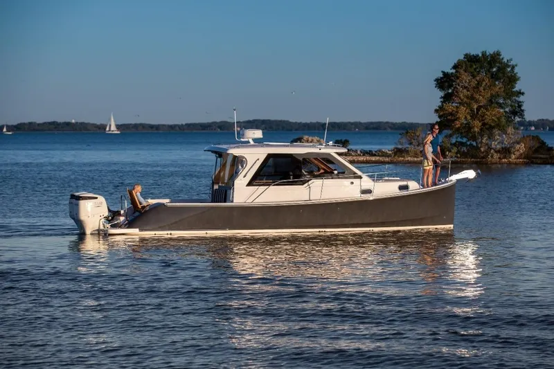 The Image of 2022 True North 34 boat cruising on a serene lake with passengers enjoying the view. - 0