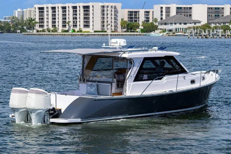 Slide: The Image of True North 34 boat, 2022 model, cruising on water near modern buildings. - 10