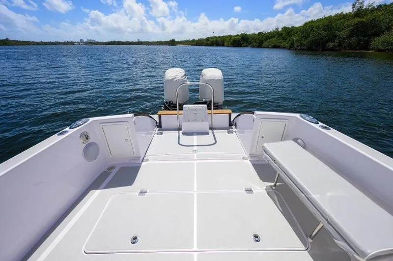 Slide: The Image of 2022 True North 34 boat deck with dual engines on a serene waterway. - 13