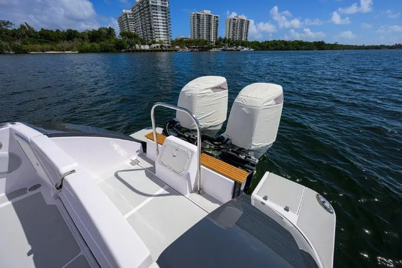 Slide: The Image of True North 34 boat on water, 2022 model, with covered engines and city skyline background. - 34