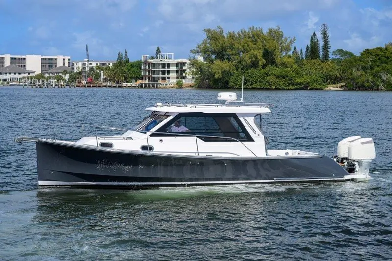 Slide: The Image of 2022 True North 34 boat cruising on a scenic waterway with lush greenery. - 4