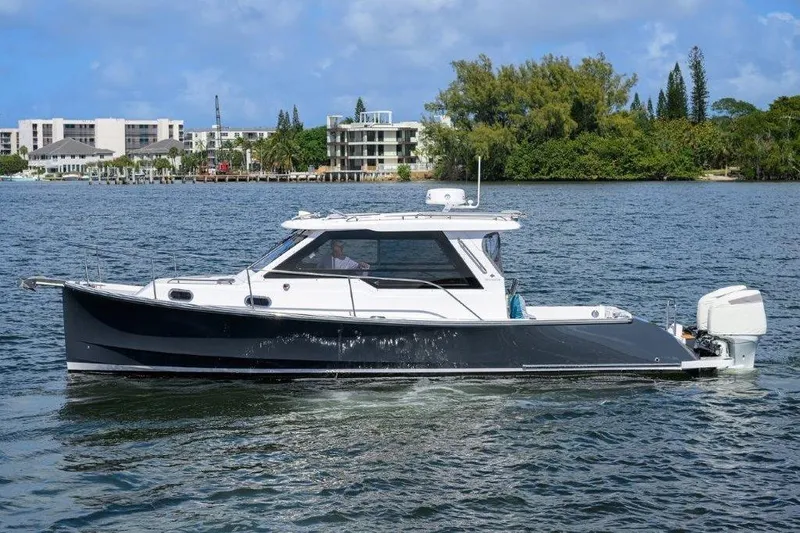 Slide: The Image of 2022 True North 34 boat cruising on a scenic waterway with lush greenery. - 6