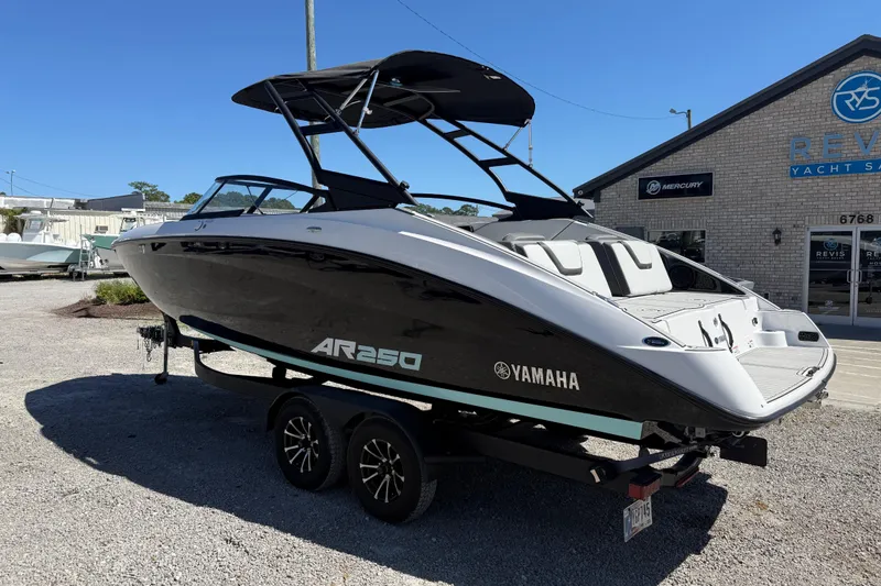 Slide: The Image of 2023 Yamaha AR250 boat on trailer at dealership, featuring sleek black and white design. - 3
