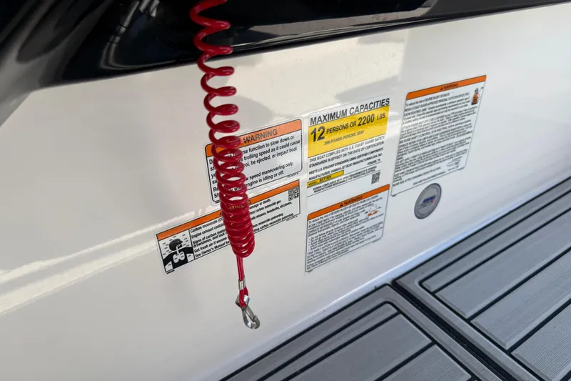 Slide: The Image of 2023 Yamaha AR250 boat safety labels and red safety lanyard on deck. - 31