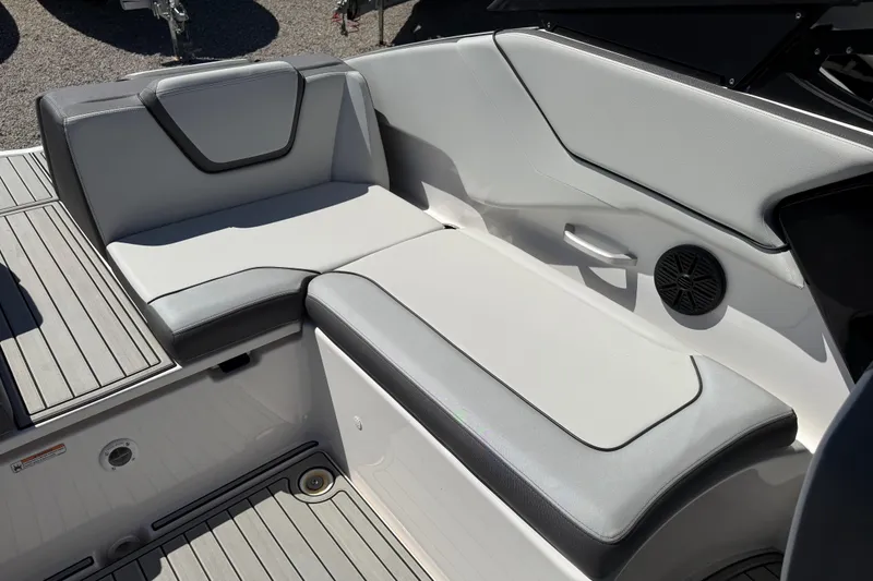 Slide: The Image of 2023 Yamaha Boats AR250 interior seating with sleek gray upholstery and integrated speaker. - 33