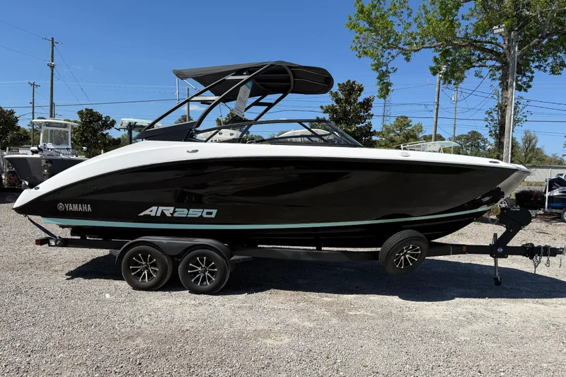 Slide: The Image of 2023 Yamaha Boats AR250 on trailer, sleek black and white design, parked outdoors. - 9