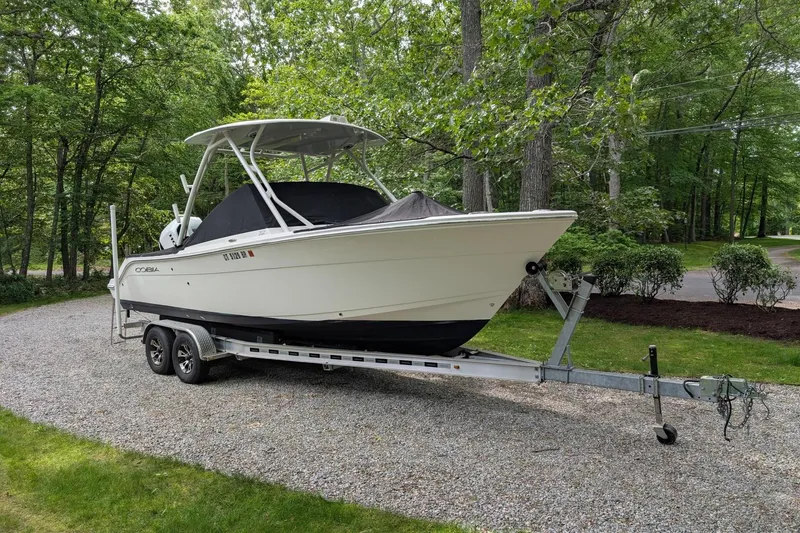 Slide: The Image of 2021 Cobia 240 Dual Console boat on trailer in wooded area. - 15