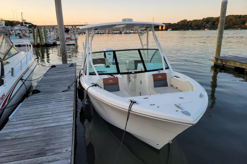 Slide: The Image of 2021 Cobia 240 Dual Console boat docked at marina during sunset. - 16