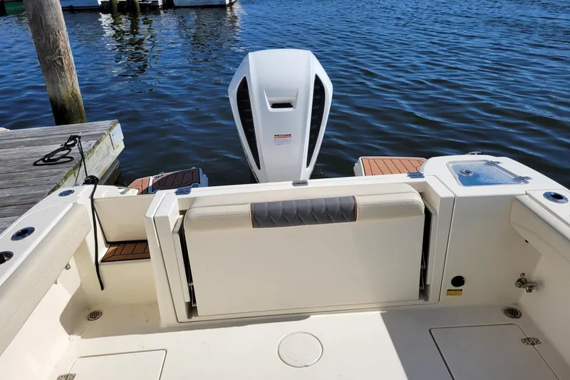 Slide: The Image of 2021 Cobia 240 Dual Console boat at dock with outboard motor. - 4
