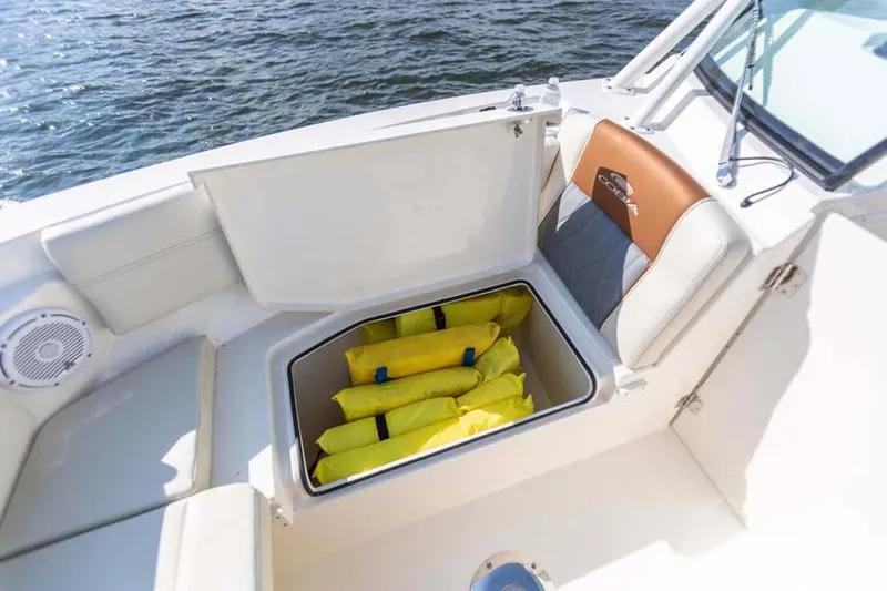 Slide: The Image of Manufacturer Provided Image: 2021 Cobia 240 Dual Console storage compartment with life jackets on a boat. - 8