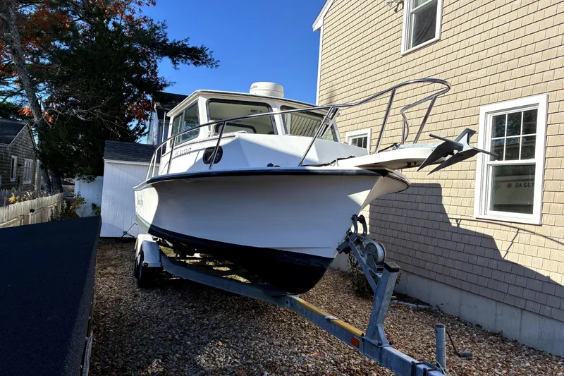 Slide: The Image of 2004 C-Hawk 25 Sport Cabin boat on trailer beside house. - 4