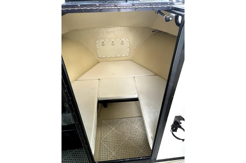 Slide: The Image of 2004 C-Hawk 25 Sport Cabin interior with cushioned seating and storage compartment. - 8