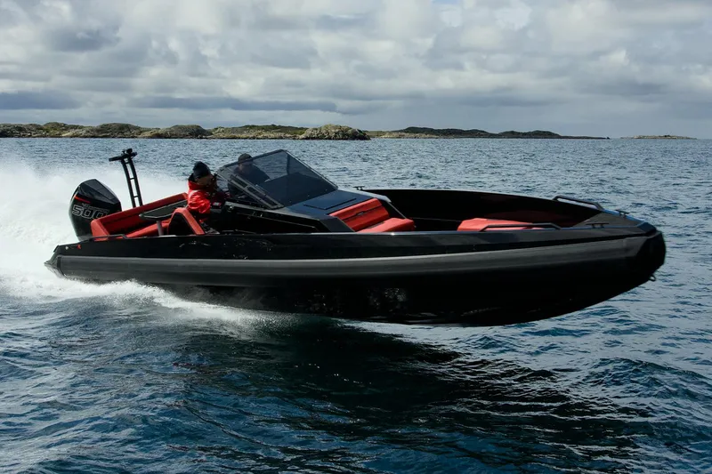 Slide: The Image of Manufacturer Provided Image: 2025 Iron 907 speedboat cruising on open water, featuring sleek black and red design. - 2
