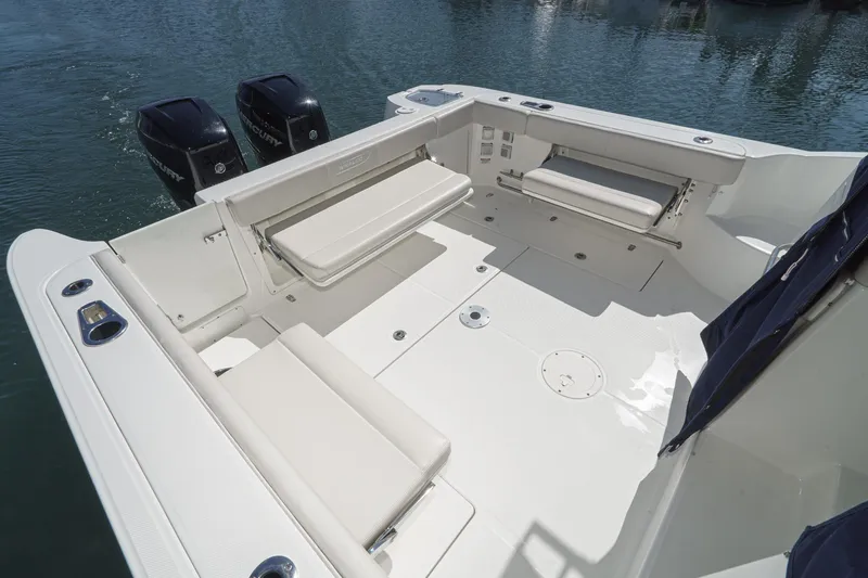 Slide: The Image of 2016 Boston Whaler 315 Conquest boat deck with seating and twin Mercury engines. - 13